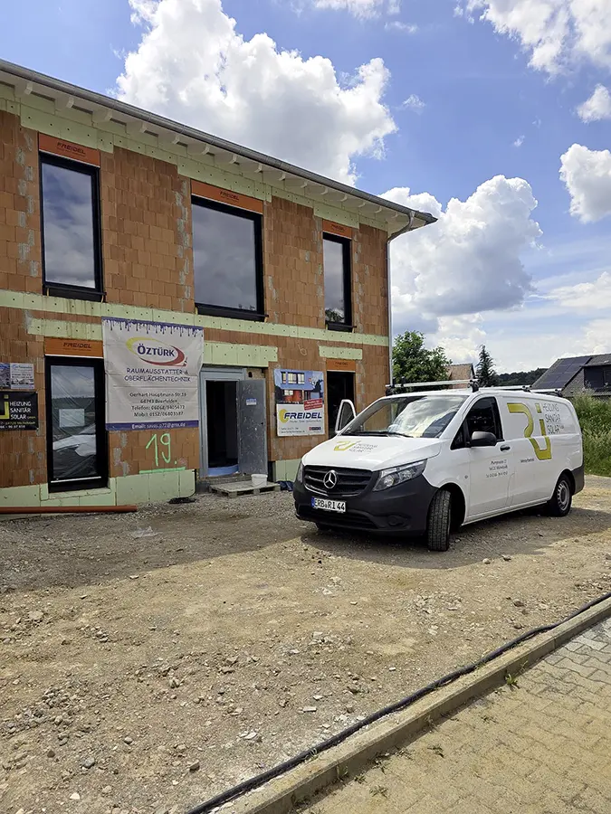 Heizungs- und Sanitärinstallation auf einer Neubau-Baustelle mit Servicefahrzeug