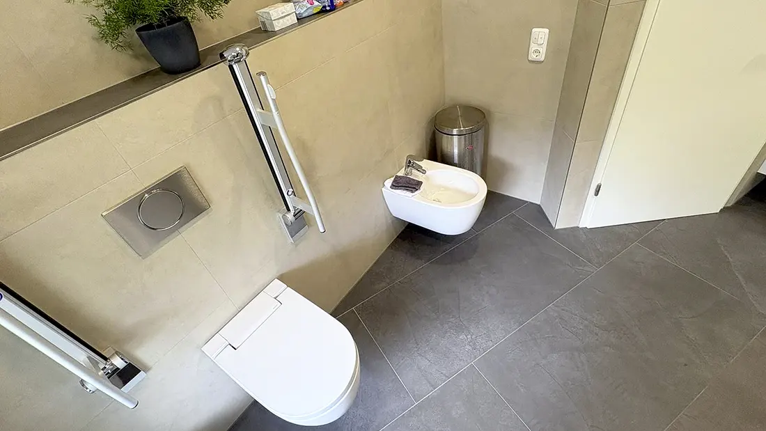 Barrierefreies WC mit Wandtoilette, Haltegriffen und Bidet